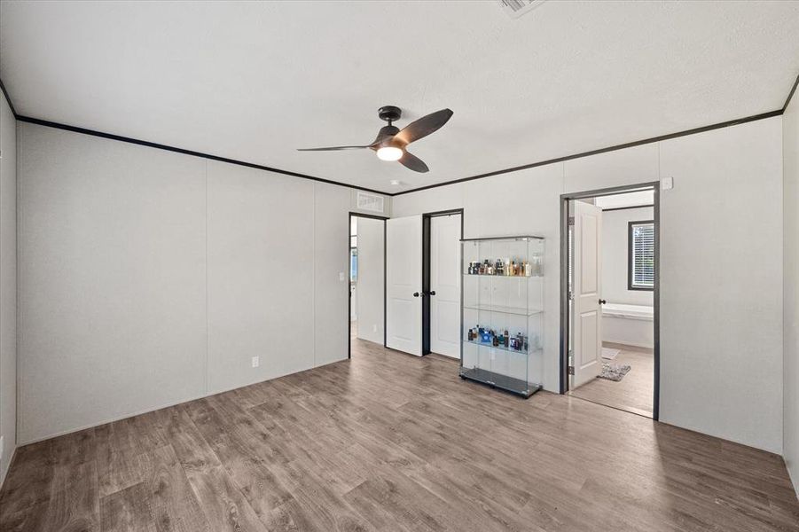 Spacious primary bedroom featuring wood-finish flooring. Spacious primary bedroom featuring wood-finish flooring.