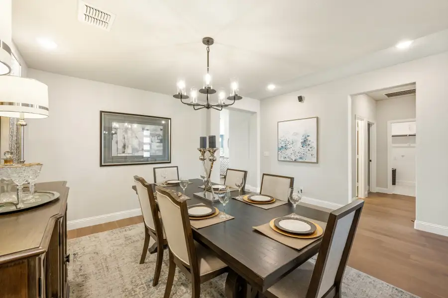 Formal dining room with dark wood table, six chairs, chandelier, and hardwood floors