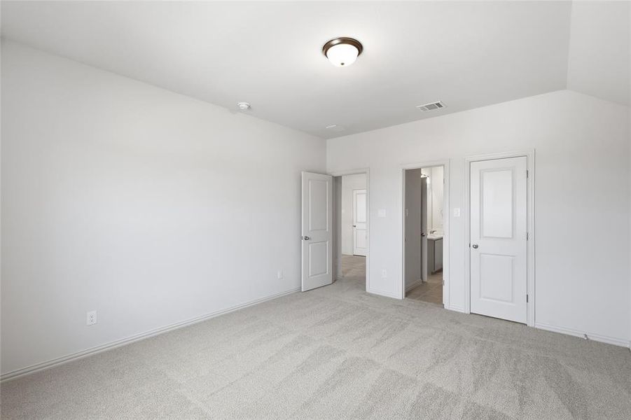 Unfurnished bedroom with light carpet and ensuite bathroom