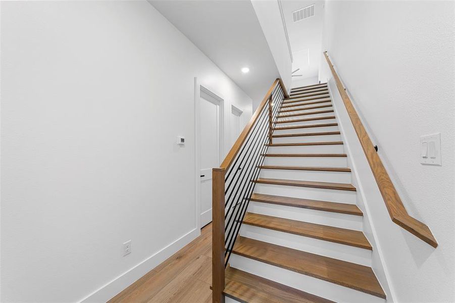 Staircase featuring wood finished floors and recessed lighting Staircase featuring wood finished floors and recessed lighting