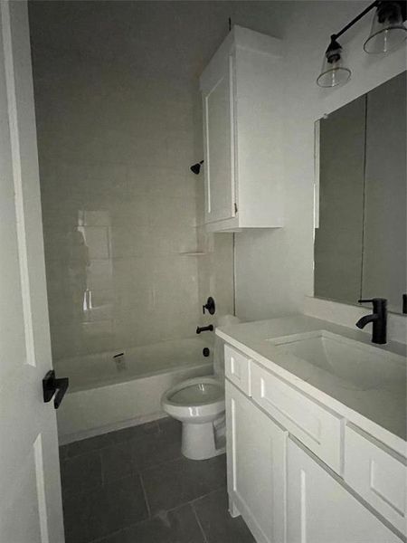 Full bathroom featuring tile patterned floors, tiled shower / bath combo, toilet, and vanity