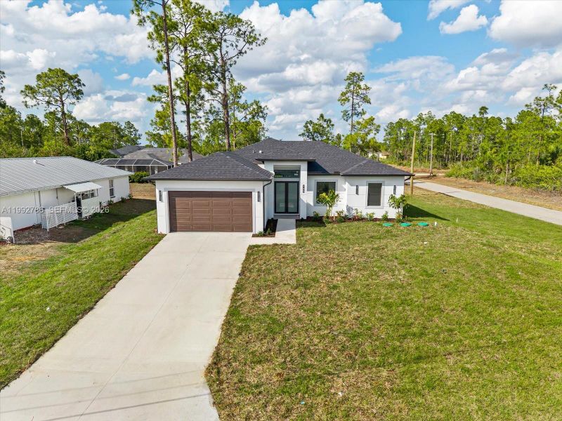 Front exterior of a new home in , Lehigh Acres, FL, highlighting curb appeal (Image 17).