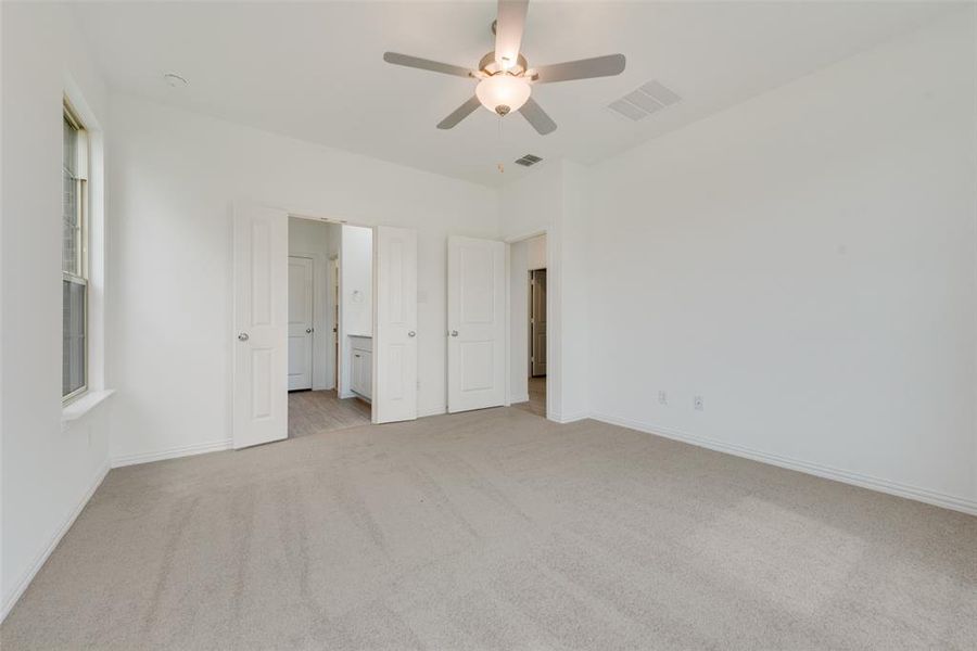 Unfurnished bedroom featuring light colored carpet and ceiling fan