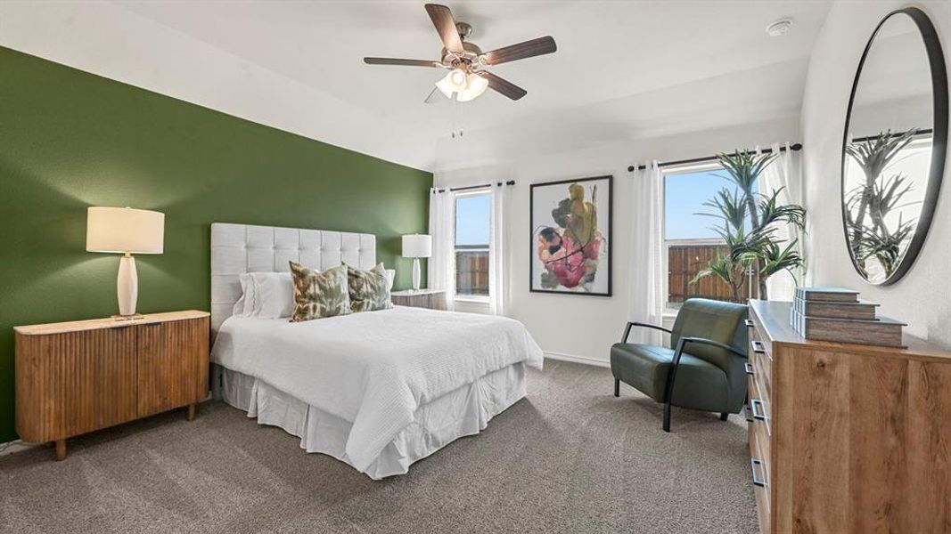 Carpeted bedroom featuring a ceiling fan and baseboards
