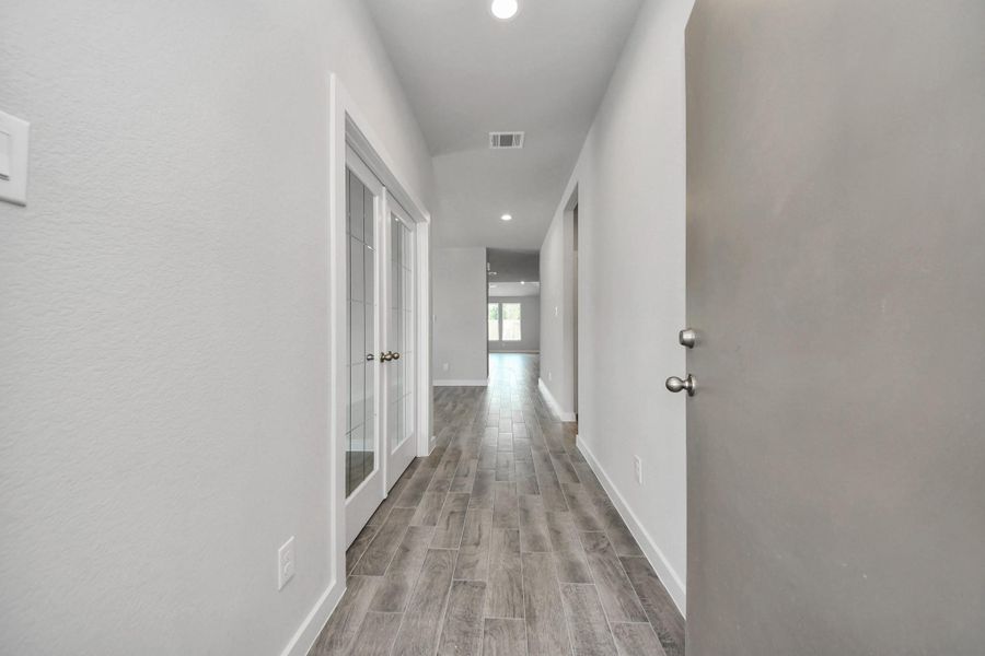 As you step into the threshold of this luxurious home, you'll soon be welcomed by an elegant glass door (to be installed). Inside, soaring ceilings amplify the spaciousness, while the refined wood-look tile flooring and oversized baseboards exude sophistication and charm. Sample photo of completed home with similar floor plan. Actual colors and selections may vary.