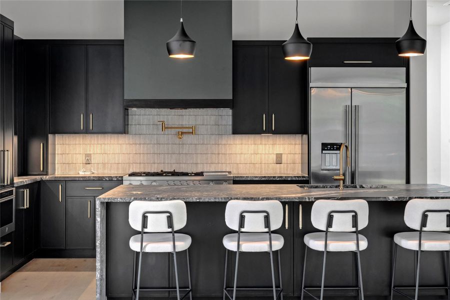 Kitchen featuring dark cabinets, stainless steel appliances, and a breakfast bar area