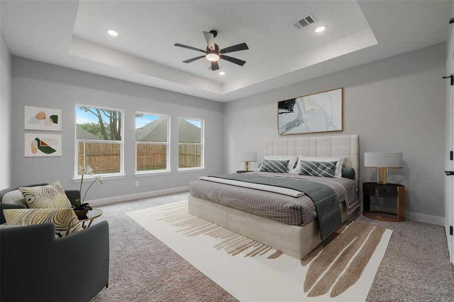 Bedroom featuring ceiling fan, a tray ceiling, and carpet floors