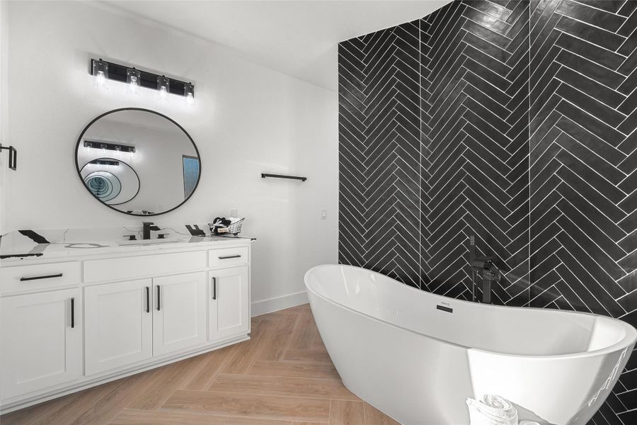 Full bathroom featuring vanity, a freestanding bath, tile walls, and an accent wall