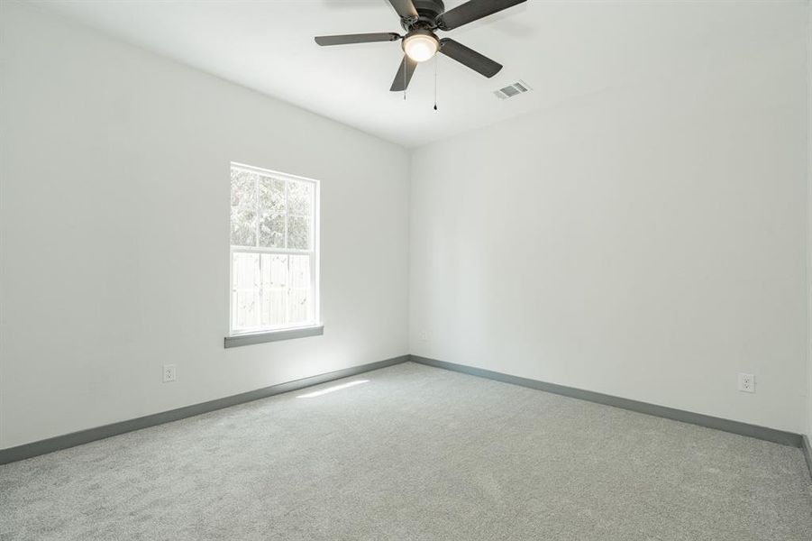 Spare room with ceiling fan and carpet floors