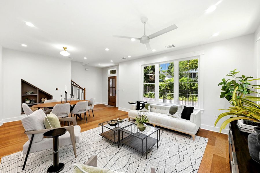 Hardwood floors and a wide window frame a naturally illuminated living space, seamlessly connecting to the dining area. Hardwood floors and a wide window frame a naturally illuminated living space, seamlessly connecting to the dining area.