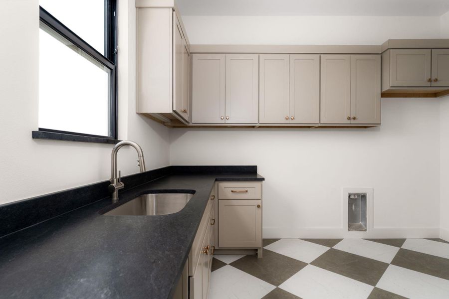 Ample cabinetry and a durable countertop make this utility space functional.