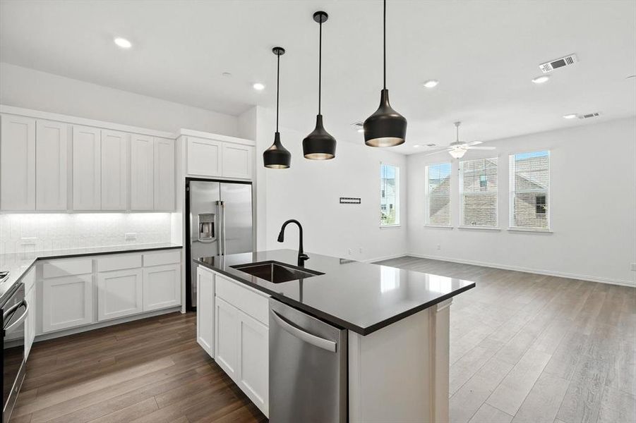 Gourmet Kitchen with stainless steel appliances. Under cabinet lighting. Open to the living room .