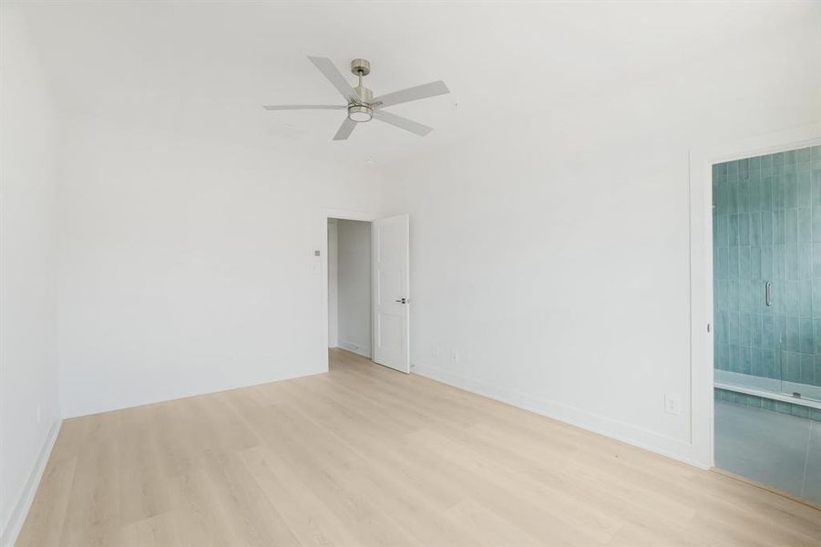 Empty room featuring light wood-style flooring, ceiling fan, and baseboards