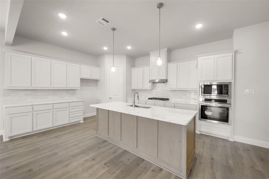 Kitchen featuring stainless steel appliances, backsplash, white cabinets, and recessed lighting Kitchen featuring stainless steel appliances, backsplash, white cabinets, and recessed lighting