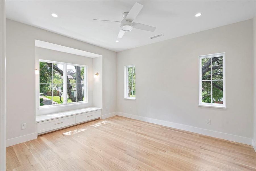 Spare room with light wood-type flooring, ceiling fan, and plenty of natural light