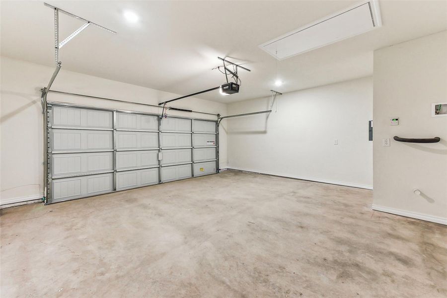 Garage featuring a garage door opener and baseboards Garage featuring a garage door opener and baseboards