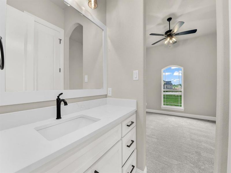 Bathroom featuring vanity, ceiling fan, and baseboards Bathroom featuring vanity, ceiling fan, and baseboards