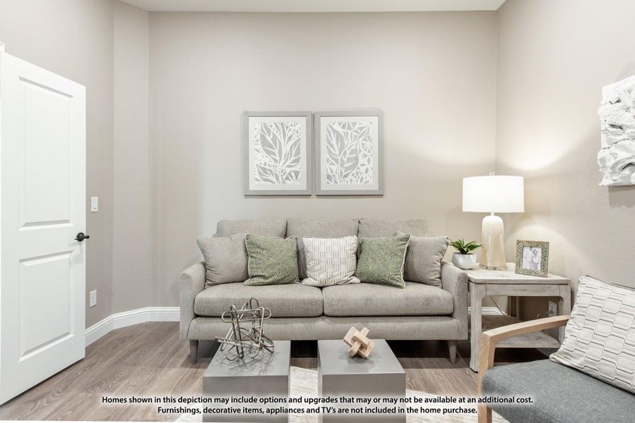 Living room with gray sofa, hardwood floors, and neutral walls with framed botanical artwork above the couch. Living room with gray sofa, hardwood floors, and neutral walls with framed botanical artwork above the couch.