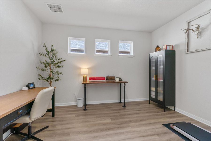 Home office with light wood finished floors and baseboards