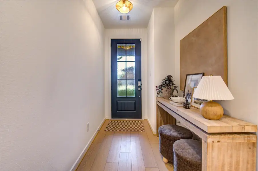 Welcome to 9727 Arrigoni Creek Drive! The inviting grand foyer sets the tone for the comfort and sophistication found throughout the home, featuring soaring ceilings, a neutral palette, and elegant vinyl flooring. Filled with natural light, this welcoming space creates an immediate sense of openness and warmth, seamlessly guiding you into the beautifully designed living spaces beyond.