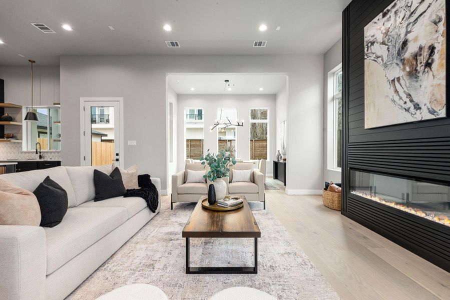 Open-concept living area with sleek fireplace flowing seamlessly into the dining space.