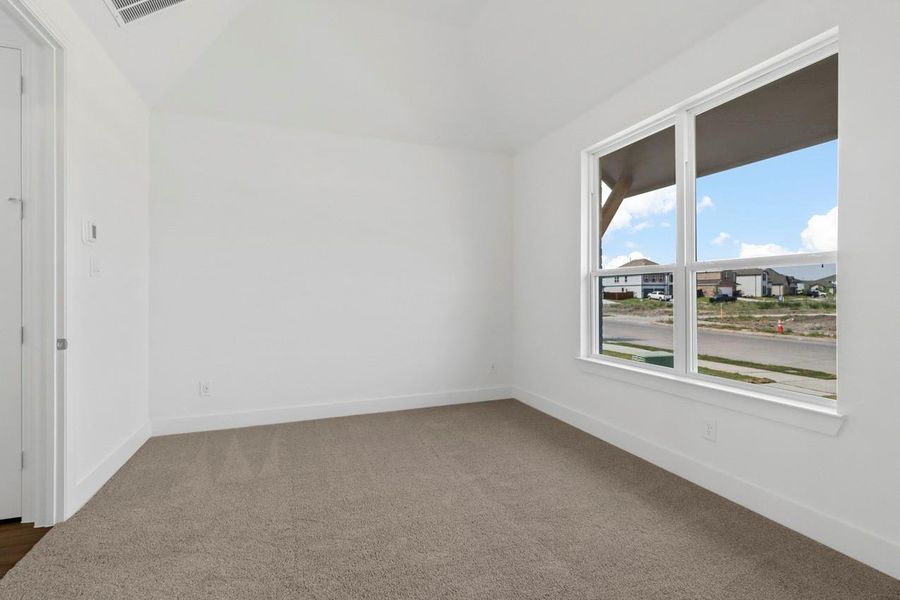 A bright primary bedroom filled with natural light from large windows, creating a warm and inviting space. A bright primary bedroom filled with natural light from large windows, creating a warm and inviting space.
