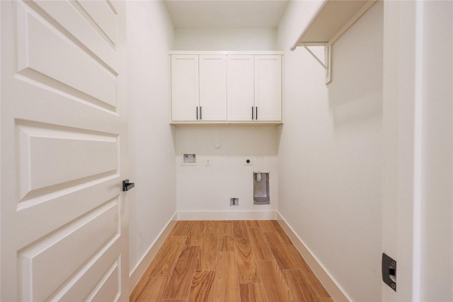 Oversized laundry room with cabinetry.