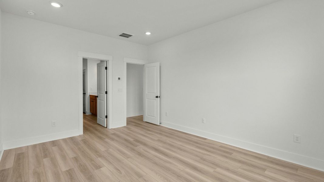 Elegant primary suite with LVP floors at Chestnut Farms by DRB Homes