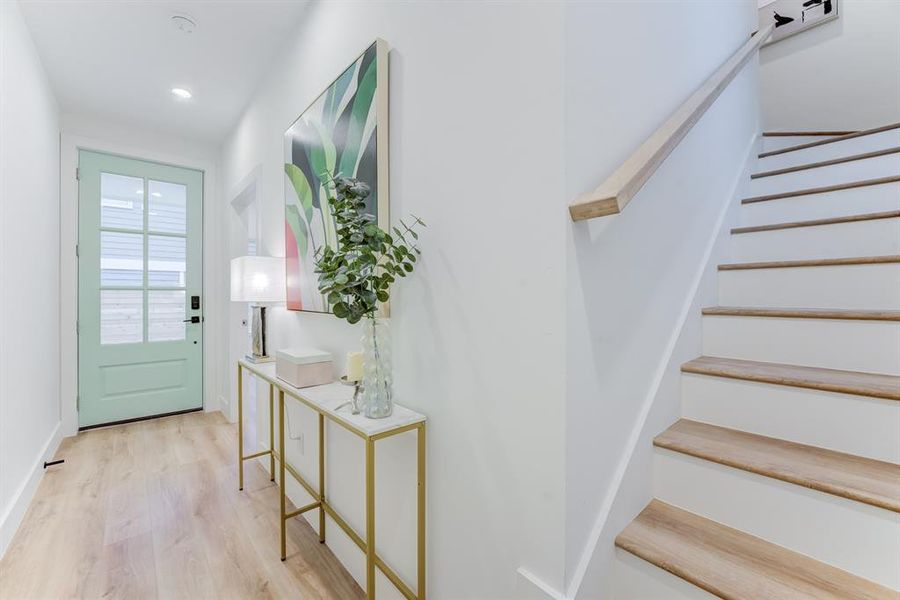 The stunning staircase and banister matches the luxury vinyl plank flooring throughout the home.