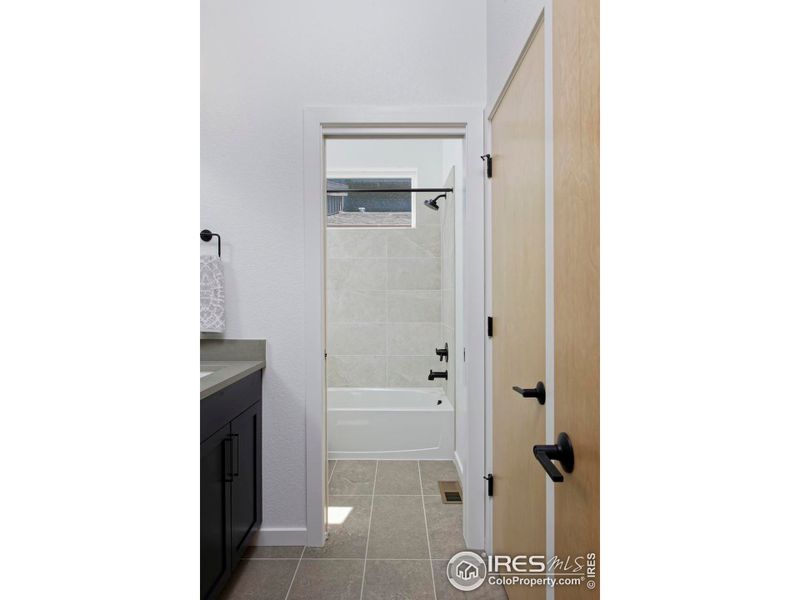 Secondary bathroom with double vanity and linen closet