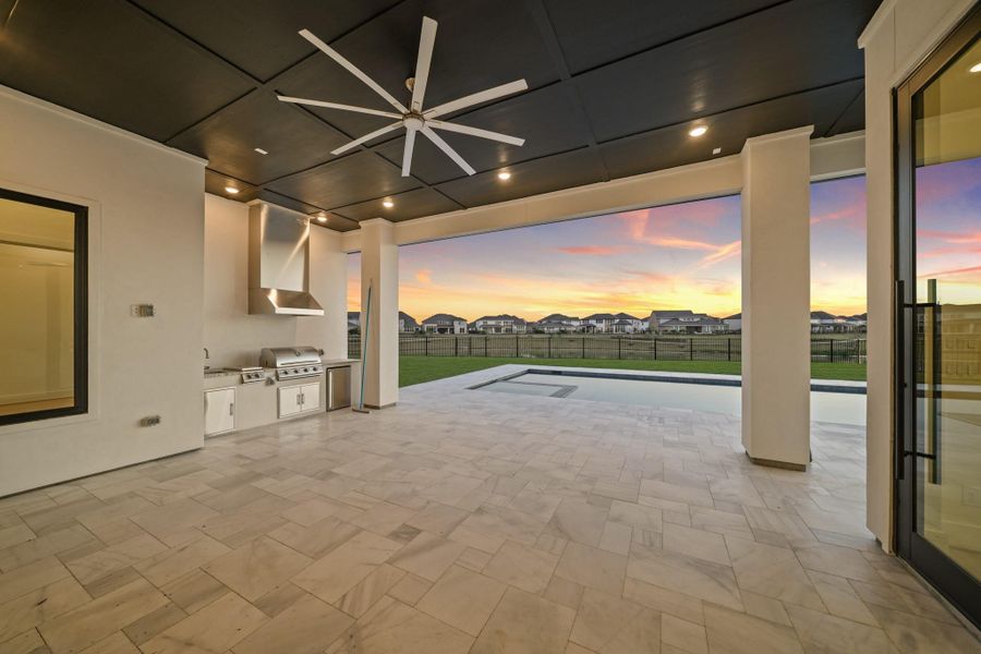 Covered patio with outdoor kitchen overlooking a pool and spacious backyard with lake views, offering an ideal setting for outdoor living and entertaining Covered patio with outdoor kitchen overlooking a pool and spacious backyard with lake views, offering an ideal setting for outdoor living and entertaining