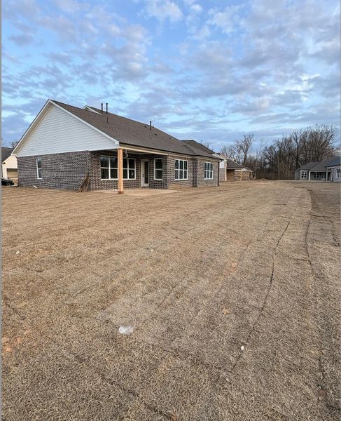 Back of property with a patio area, brick siding, and a yard