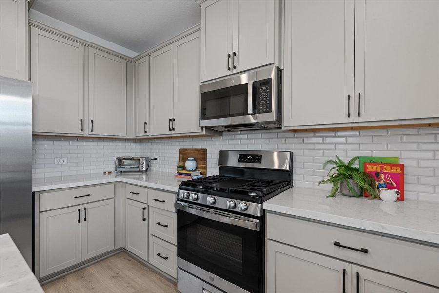Kitchen featuring stainless steel appliances, gray cabinets, center island, and recessed lighting