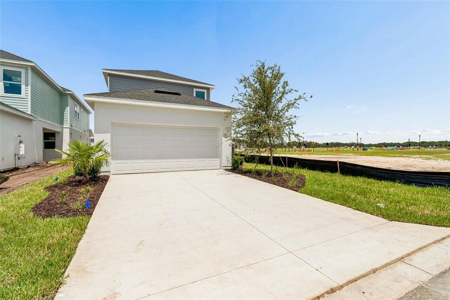 Front exterior of a new home in Palmeras at Crossprairie – The Magnolia Collection, St. Cloud, FL, highlighting curb appeal (Image 16).