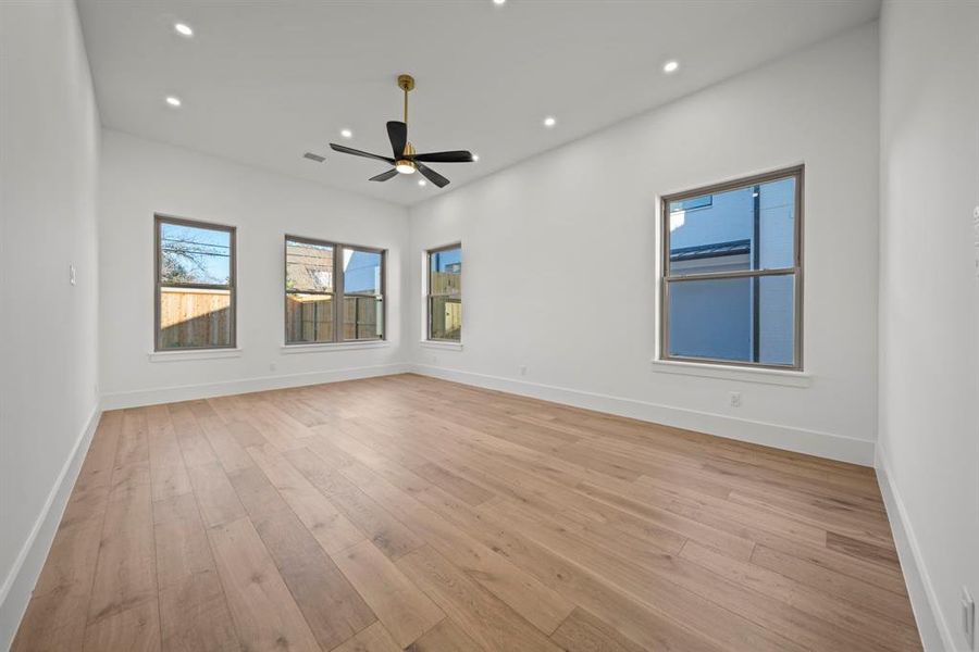 This spacious Third bedroom features beautiful wood flooring and large windows that provide abundant natural light and a view of the backyard. The modern ceiling fan adds style and comfort, making this room perfect as a guest bedroom or a private retreat. With its clean design and serene ambiance, this space is ready to accommodate your personal touch.