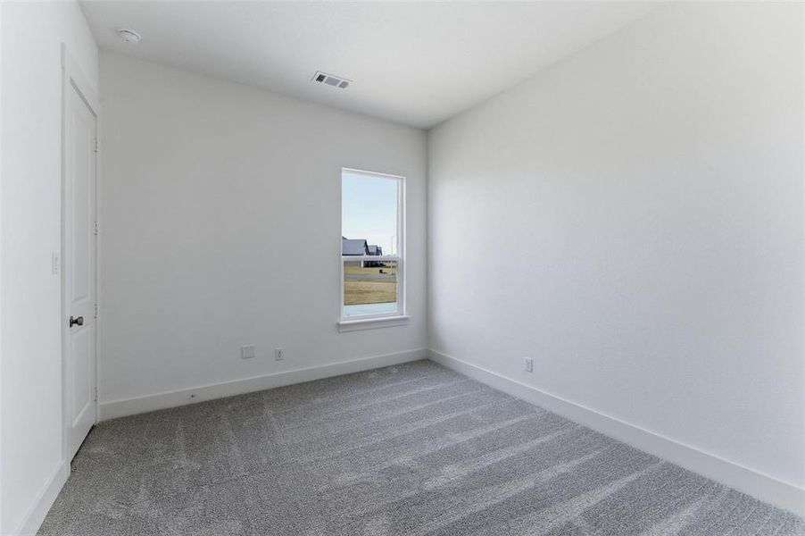 Carpeted spare room with baseboards