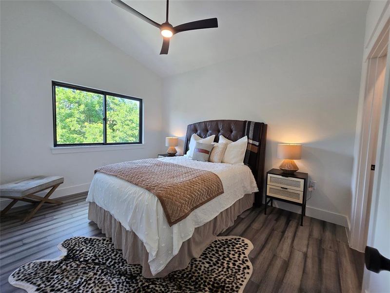 Secondary bedroom with a vaulted ceiling and a large window. Lots of space here as well.