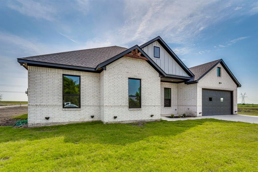 View of front of home featuring a garage and a front yard