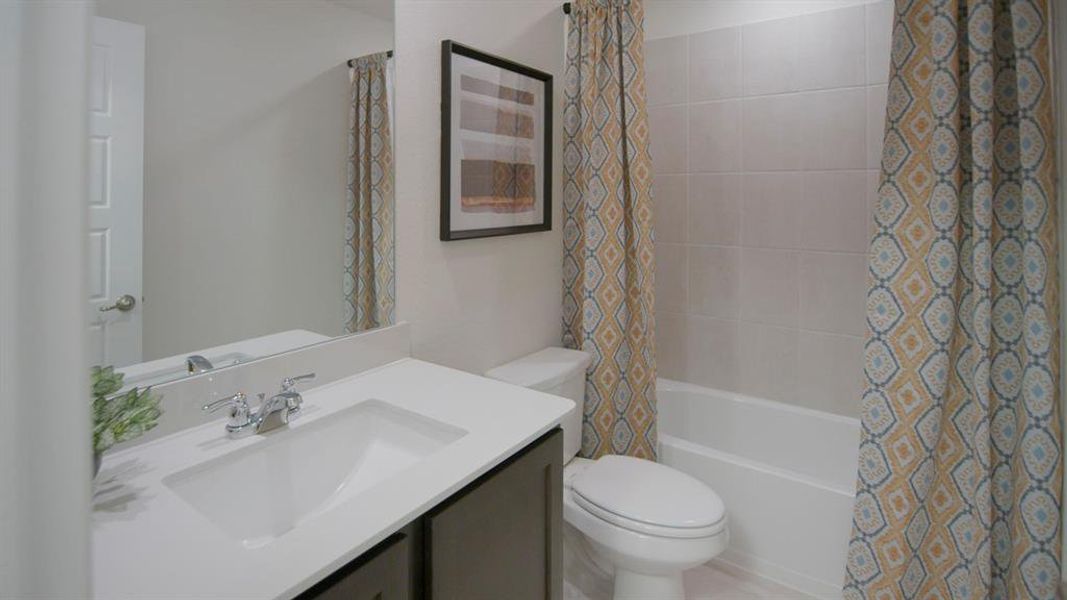 Bathroom featuring a vanity with an integrated sink, polished chrome faucet, and dark wood-finish cabinetry Bathroom featuring a vanity with an integrated sink, polished chrome faucet, and dark wood-finish cabinetry