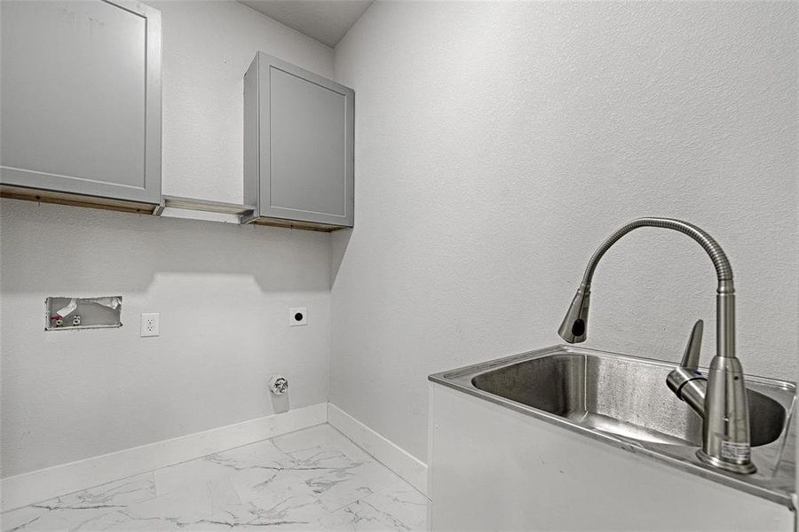 Laundry room featuring cabinets, hookup for a washing machine, sink, and electric dryer hookup