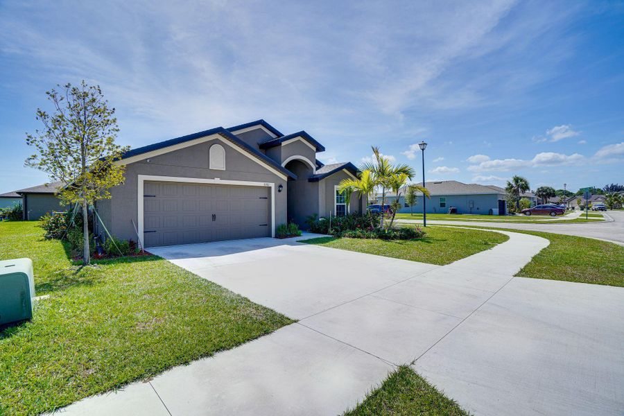 Front exterior of a new home in Celebration Pointe, Fort Pierce, FL, highlighting curb appeal (Image 19).