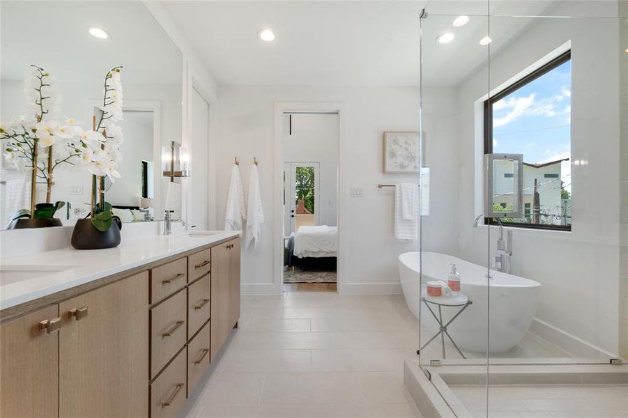 Bathroom with vanity, a bathing tub, and tile patterned flooring