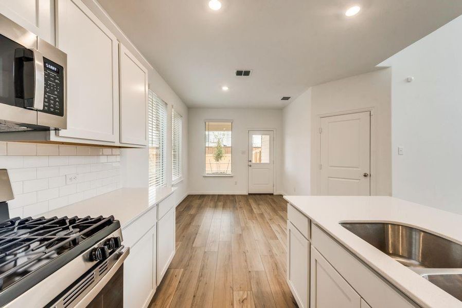 Kitchen featuring appliances with stainless steel finishes and white cabinets