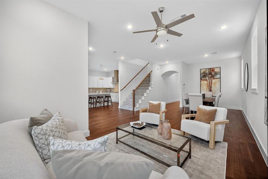 Living area with stairway, wood finished floors, recessed lighting, ceiling fan, and arched walkways