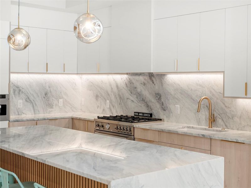 Kitchen with modern cabinets, light stone countertops, appliances with stainless steel finishes, and white cabinets Kitchen with modern cabinets, light stone countertops, appliances with stainless steel finishes, and white cabinets