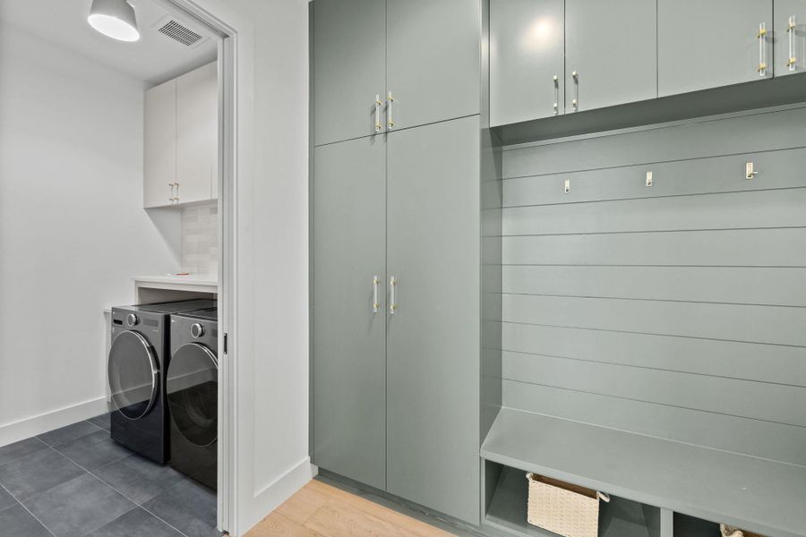 Laundry room featuring cabinet space, washing machine and clothes dryer, and light tile patterned flooring