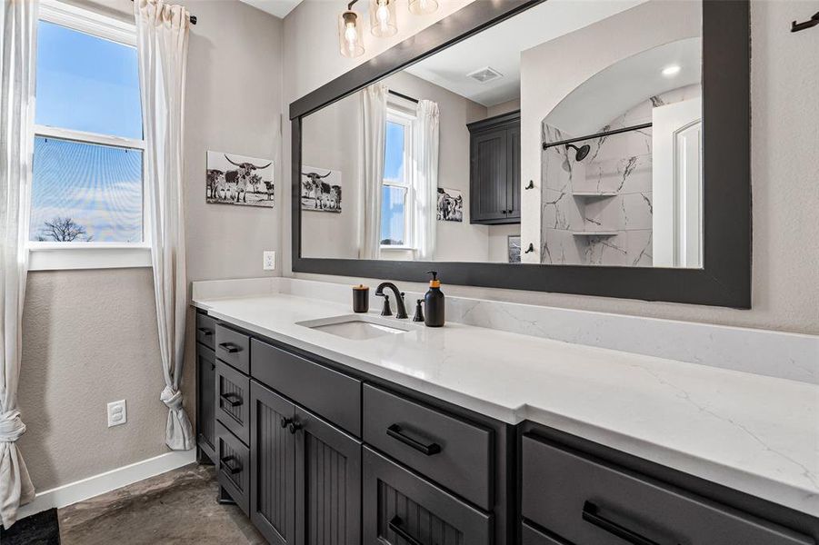 Bathroom featuring a marble finish shower and vanity Bathroom featuring a marble finish shower and vanity