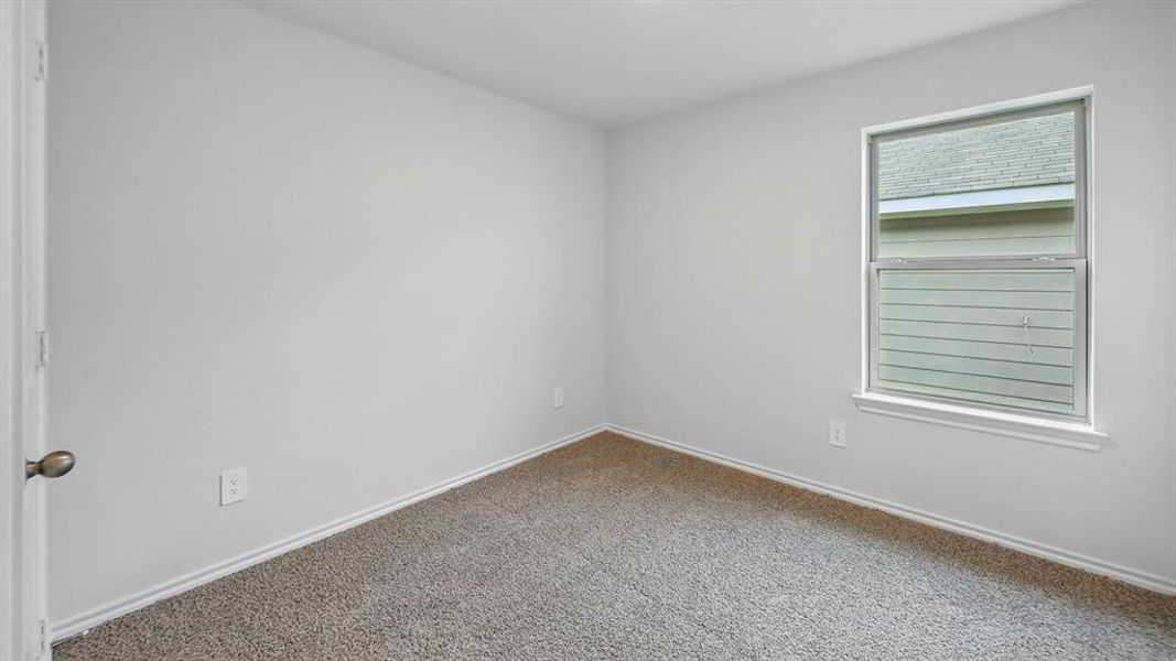 Spare room featuring baseboards and carpet flooring