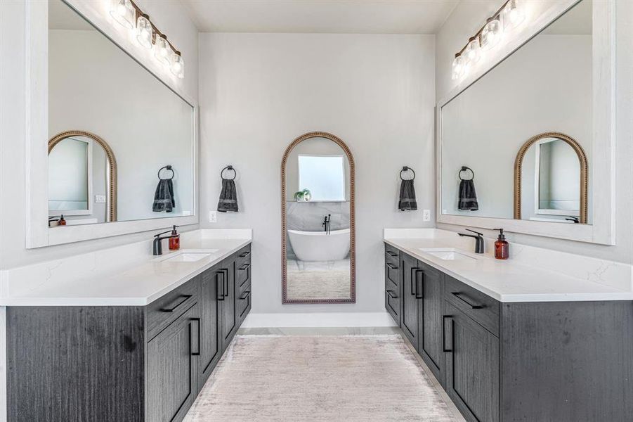 Full bathroom with two vanities and a soaking tub