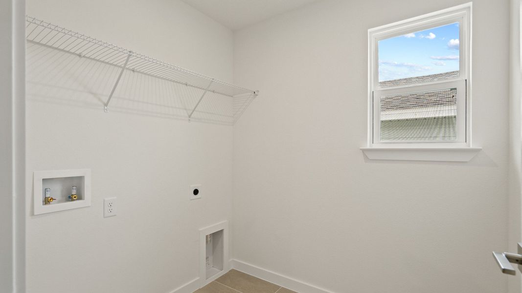 Second bedroom walk-in closet with built-in shelving and window—offering practical storage and a bright, airy feel
